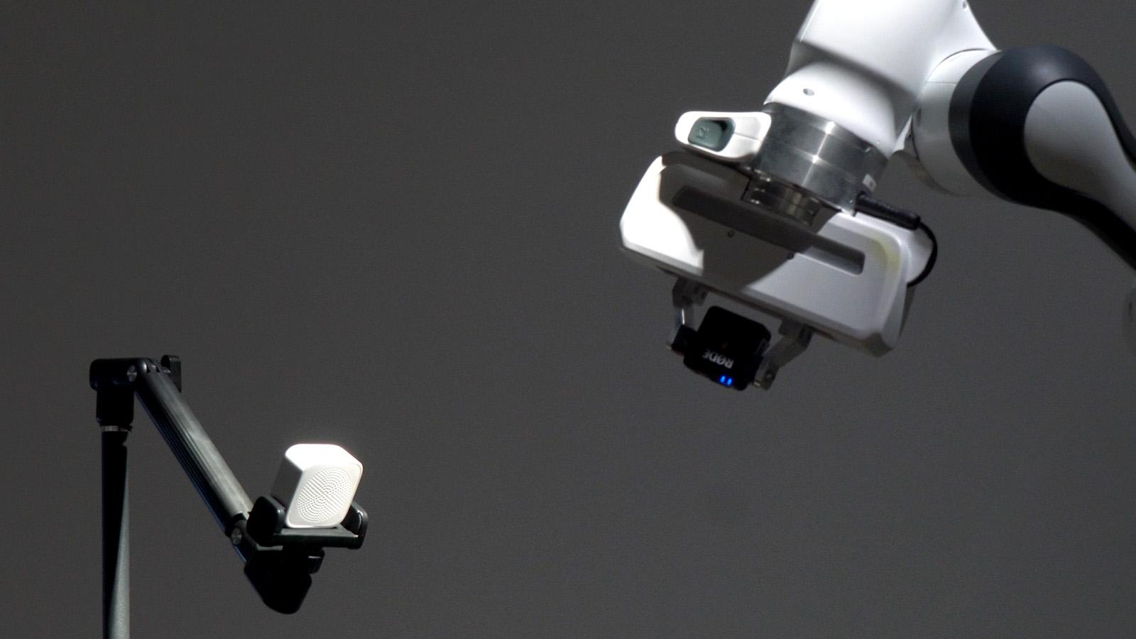 Franka arm listening for the strongest audio signal in a darkened gallery